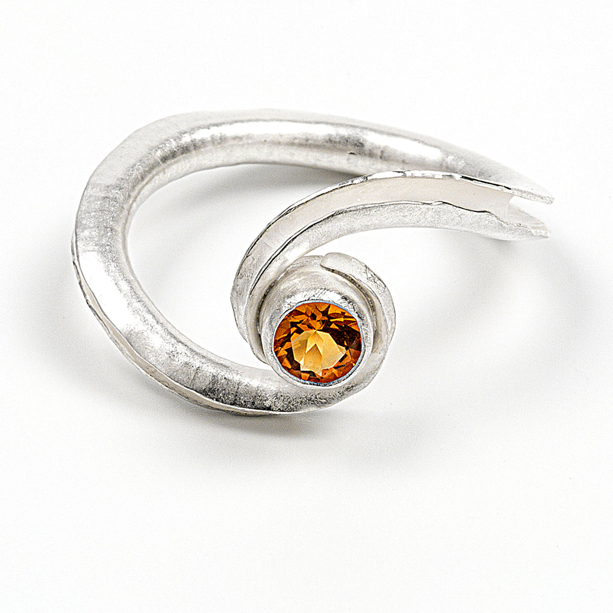 A silver birthstone ring handmade from recycled sterling silver, with a gemstone cradled between two curling ends. Shown here is the citrine variant for November, from the front and slightly above.